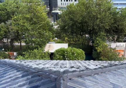 Close-up of wooden fixing battens installed on the roof deck with triple-arch solar tile sections being positioned, electrical wiring visible between rows